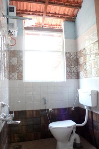 a bathroom with a toilet and a window at The Inchara Hill View HomeStay in Chikmagalūr
