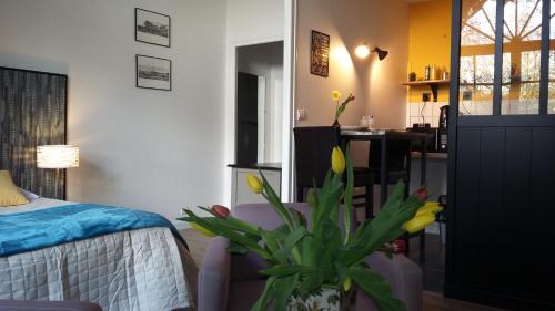 a bedroom with a bed and a potted plant at Les Tulipiers, Parking Sécurisé, Lit Queen-Size, le Mans Centre in Le Mans