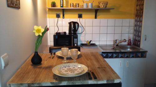 a kitchen with a wooden table with a vase of flowers at Les Tulipiers, Parking Sécurisé, Lit Queen-Size, le Mans Centre in Le Mans