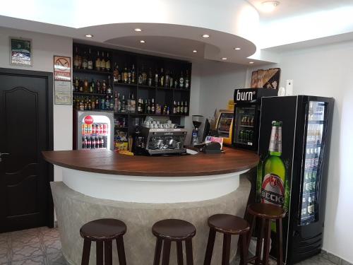 a bar with stools and a bottle of beer at Cristal Sinaia in Sinaia