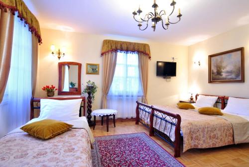 1 dormitorio con 2 camas y lámpara de araña en Dworek Ojca Mateusza, en Sandomierz