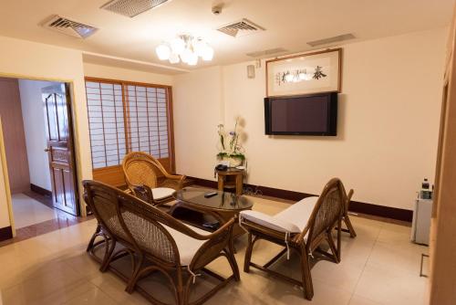 a living room with a table and chairs and a tv at Taihu Hotel Sun Moon Lake in Yuchi