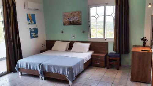 ein kleines Schlafzimmer mit einem Bett und einem Fenster in der Unterkunft Galini Apartments in Plakias