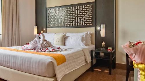 a hotel room with a large bed with towels on it at White Mansion 白色公馆 in Phnom Penh