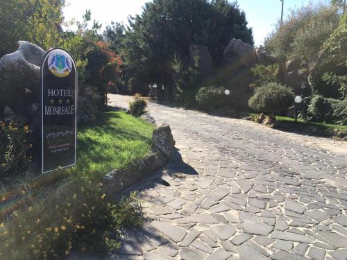 a sign on the side of a stone road at Hotel Monreale in Sardara