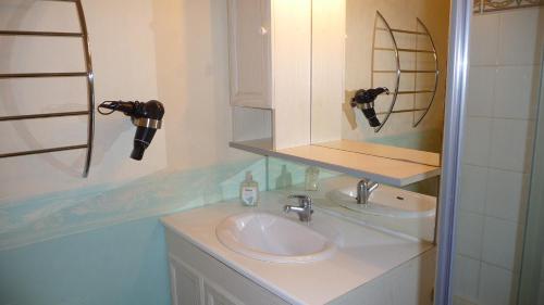 une salle de bain avec un lavabo et un miroir dans l'établissement Le Perigord, à Sarlat-la-Canéda
