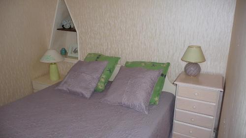 une chambre avec un lit avec des draps violets et deux lampes dans l'établissement Le Perigord, à Sarlat-la-Canéda