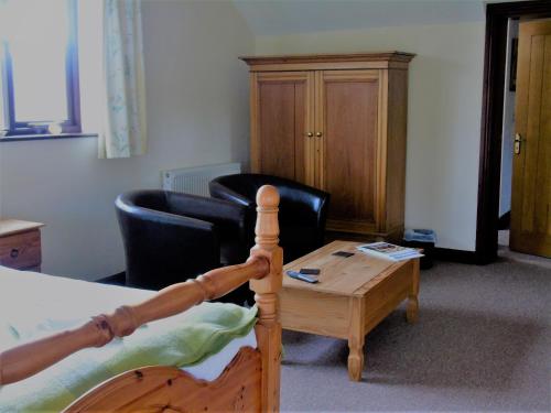 a living room with a bed and a coffee table at Pwllgwilym B & B in Builth Wells
