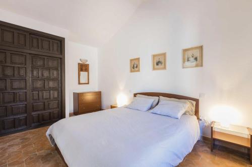 プエルト・デル・カルメンにあるVivienda Vacacional Casetta Volanteのベッドルーム(白い大型ベッド、ランプ2つ付)
