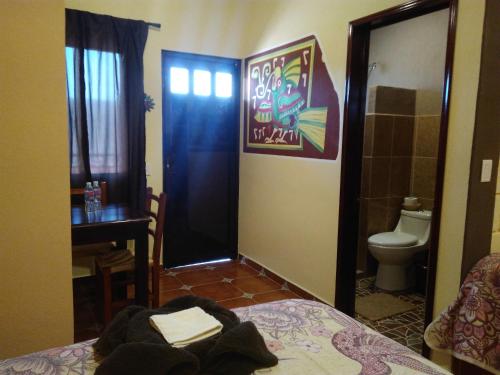 a room with a bed and a bathroom with a toilet at El Sueño de Quetzalcoatl in San Juan Teotihuacán