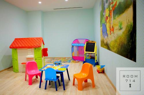 a room with a table and chairs and a toy house at ORBI Palace Deluxe in Bakuriani