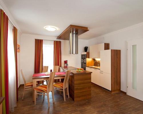 a kitchen and dining room with a table and chairs at Parkvilla Appartements in Bad Hofgastein