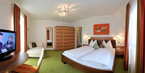 a bedroom with a bed and a flat screen tv at Parkvilla Appartements in Bad Hofgastein