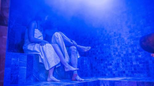 two girls sitting on steps in a blue room at Hotel Le Alpi in Livigno