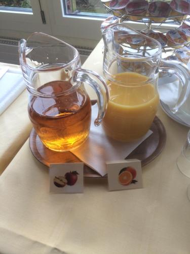 two glasses of honey and a pitcher of orange juice at Hotel Restaurant Heidihof in Maienfeld