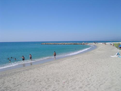 a group of people walking on a beach at B&B Acquachiara in Roccella Ionica