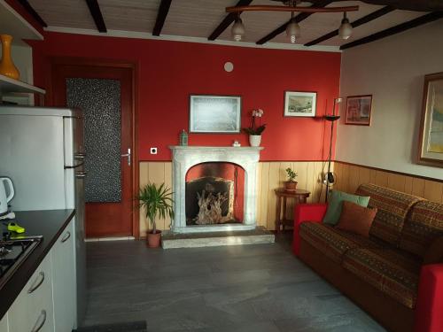 a living room with a fireplace and red walls at Casa Bartula in Bolzano Novarese