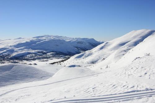 a snow covered mountain with people skiing down a snow covered slope at Suigard Veslestugo in Sauland