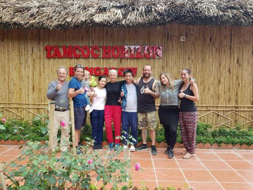 a group of people posing for a picture in front of a building at Tam Coc Horizon Bungalow in Ninh Binh
