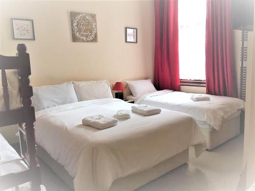 a bedroom with two beds with towels on them at Lyndhurst Hotel in Blackpool