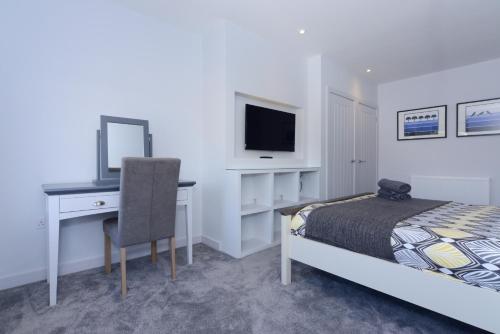 a bedroom with a bed and a desk with a computer at Sandbanks Road in Poole