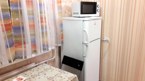 ウシンスクにあるАпартаменты на Возейской, 3 (6эт)の冷蔵庫(電子レンジ付)が備わる客室です。