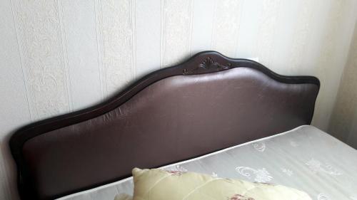 ウシンスクにあるАпартаменты на Возейской, 3 (7эт)の茶色のベッドのヘッドボード(枕付)