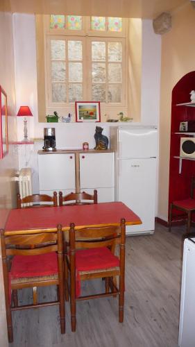 - une cuisine avec une table, des chaises et une table dans l'établissement La Salamandre, à Sarlat-la-Canéda