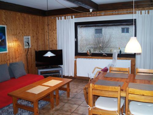 a living room with a red couch and a table at Ferienwohnung An der Innerste in Wildemann