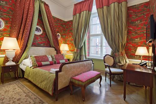 sypialnia z łóżkiem, biurkiem i zasłonami w obiekcie The Bonerowski Palace Boutique Hotel w Krakowie