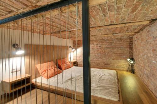 ブダペストにあるPalace Loft Superiorのレンガの壁にベッド1台が備わるベッドルーム1室