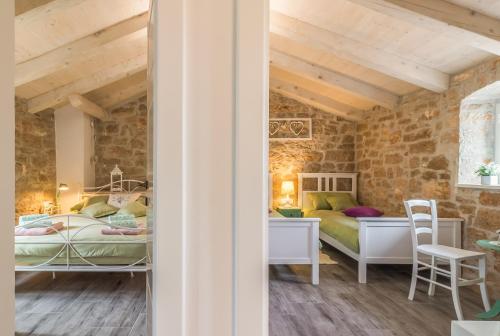 a bedroom with two beds and a desk and chairs at Villa Nonni-romantic stone house in Višnjan