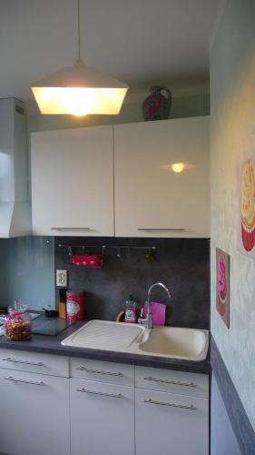 une cuisine avec des armoires blanches et un évier dans l'établissement La Bonbonnière, à Sarlat-la-Canéda