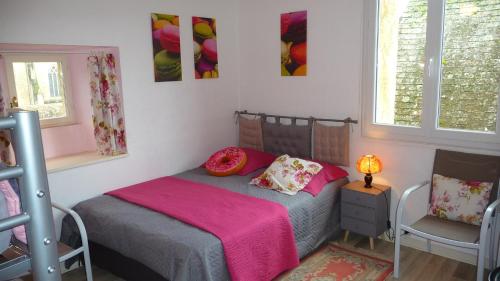 une chambre avec un lit avec une couverture rose dans l'établissement La Bonbonnière, à Sarlat-la-Canéda