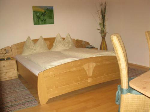 a wooden bed in a room with a table at Bio-Bauernhof-Hotel Matlschweiger in Lassing