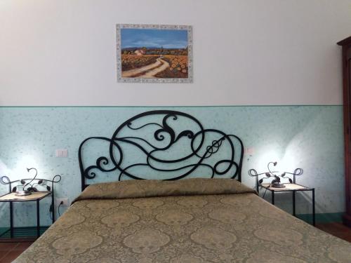 a bedroom with a bed with a painting on the wall at Agriturismo Colleverde Capalbio in Capalbio