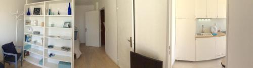une chambre avec des armoires blanches et un couloir dans l'établissement Natalilocs, au Golfe-Juan