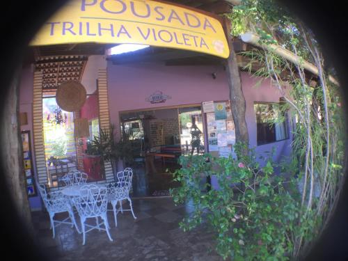 a restaurant with a table and chairs in front of it at Pousada Trilha Violeta in Sao Jorge