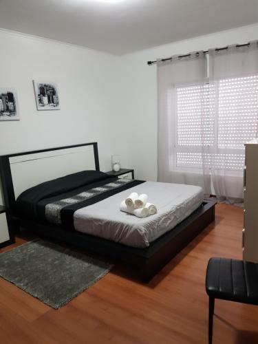 um quarto com uma cama e uma janela em Apartamento Moderno e Elegante em Ponta Delgada