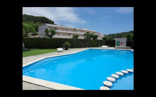 a large blue swimming pool with a building in the background at Cala Azul 304-306 Tamarit in Tamarit