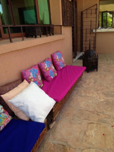 a couch sitting on the side of a building with pillows at Ferme D"Hote Lala Fatima in Aïn Leuh