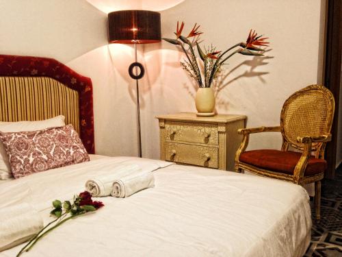 a bedroom with a bed with a dresser and a chair at Vila Algarvia Boutique & Suites in Albufeira