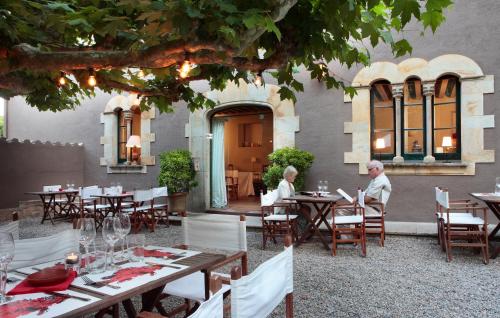 two people sitting at tables in a restaurant at Hostal Sa Rascassa in Begur