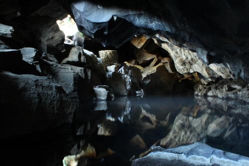 a cave with a pool of water in it at Birkilauf in Myvatn