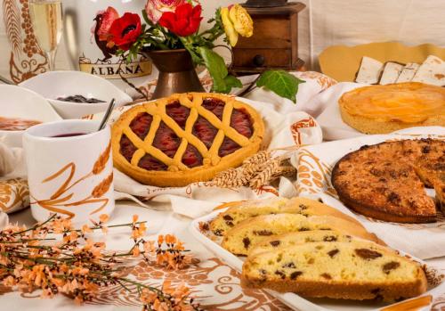 a table with pies and bread and a basket of flowers at Hotel Felix in Rimini