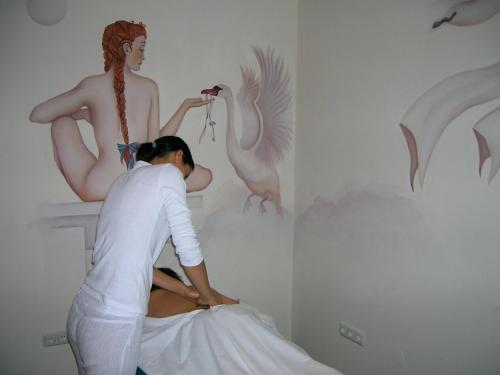 a woman in a room with a painting of a mermaid at Bio-Bauernhof-Hotel Matlschweiger in Lassing