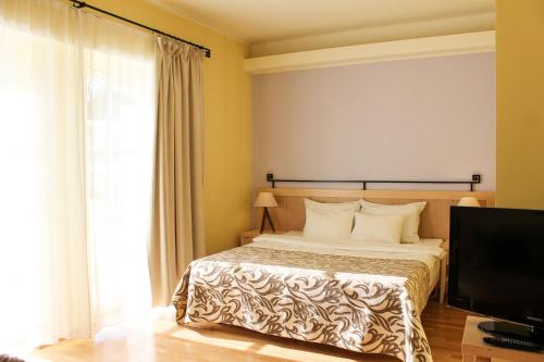 a bedroom with a bed and a flat screen tv at Sagadi Manor Hotel in Sagadi