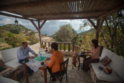 a group of people sitting around a table on a patio at Hoyran Wedre Country Houses in Davazlar