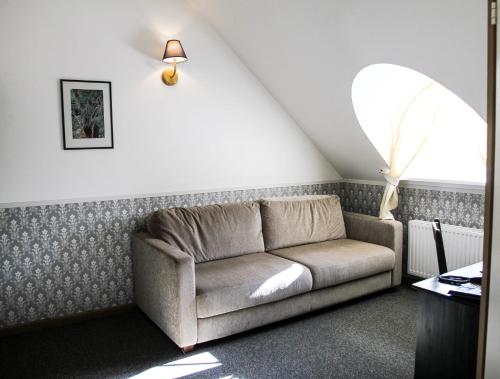a living room with a couch in a attic at Sagadi Manor Hotel in Sagadi
