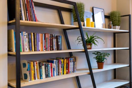a book shelf filled with books and plants at HOTEL Bee Station in Kyiv